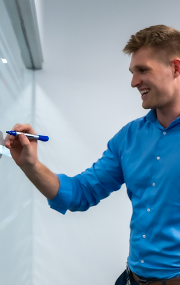 Engineer brainstorming and writing on whiteboard