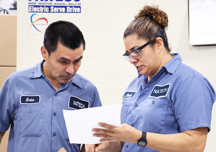 two medical injection molding operators reviewing process