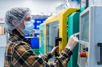 engineer using an injection molding machine in a cleanroom