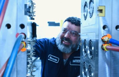 Technician inspecting an injection mold during mold transfer evaluation process