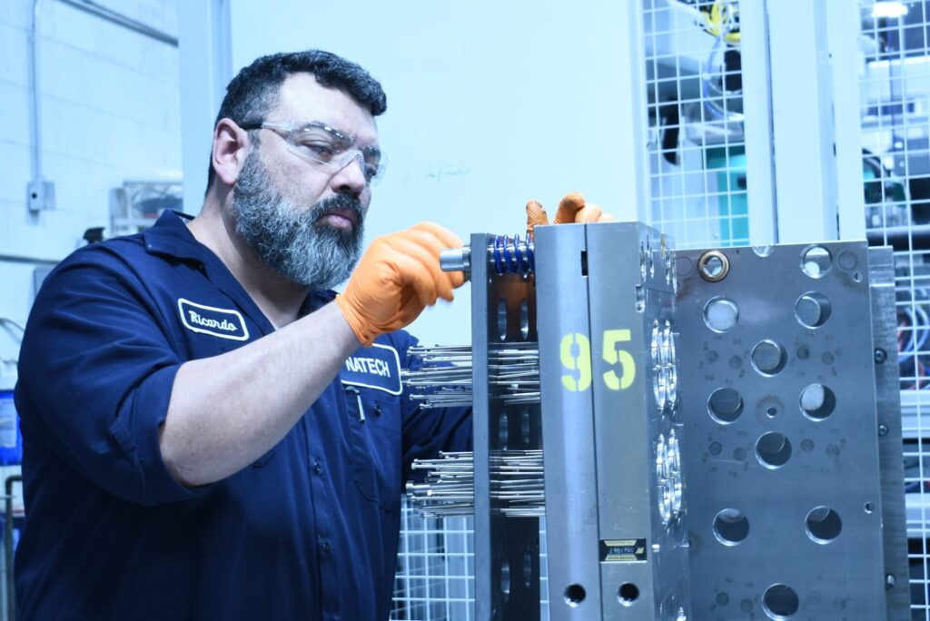 Technician inspecting an open injection mold during the evaluation phase of a mold transfer