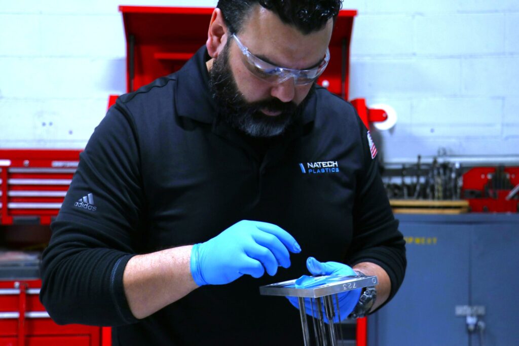 Technician adjusting mold components during the optimization phase of a mold transfer