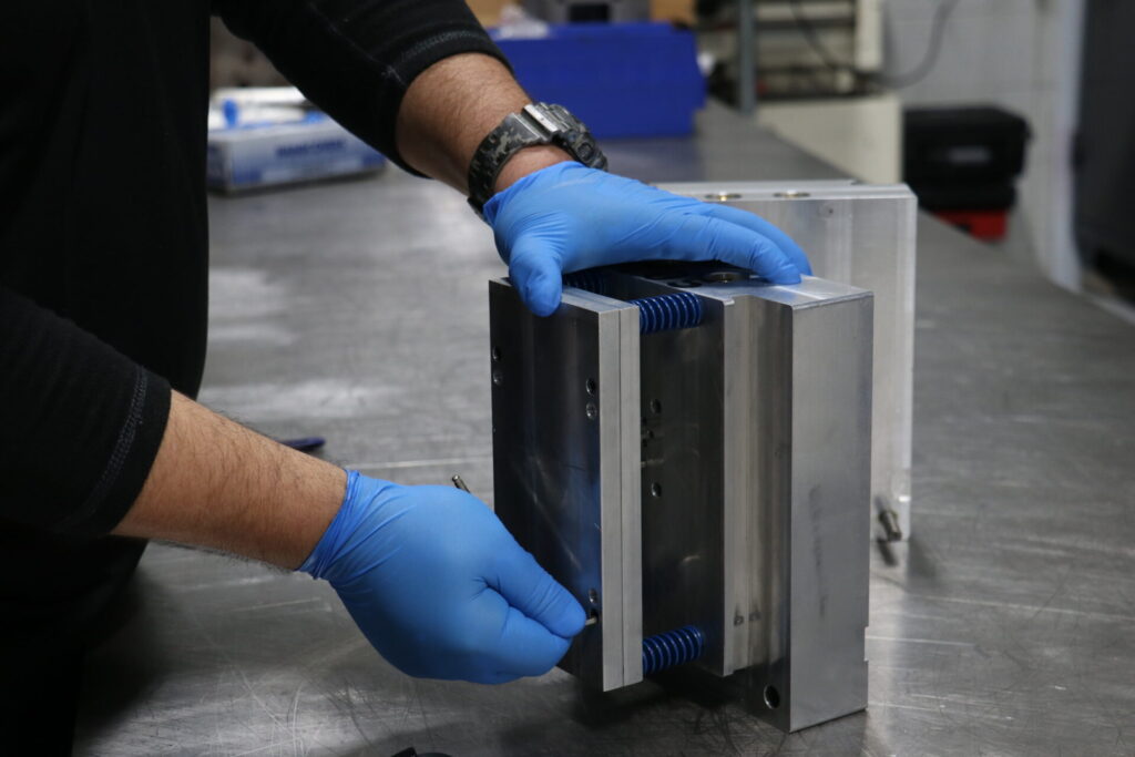 Engineer inspecting and fine-tuning mold components during mold optimization