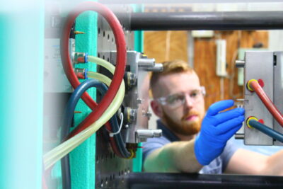 An engineer repairing an injection molding machine.